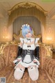 A woman in a maid outfit sitting on a couch.