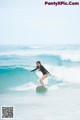 A woman riding a wave on top of a surfboard.