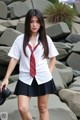 A woman in a school uniform posing for a picture.